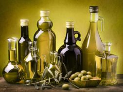 olio-bottiglie-anonime-olive-foglie-sfondo-verde1